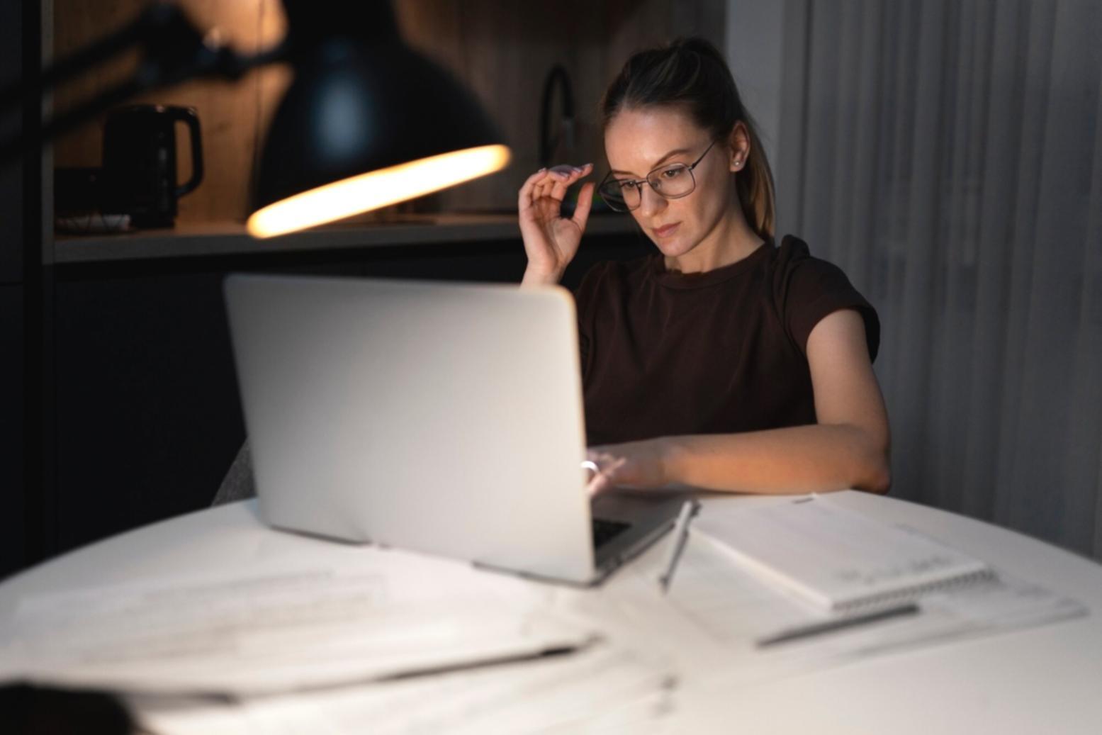 Estudiante revisando modelo financiero en ordenador con hojas de cálculo y gráficos